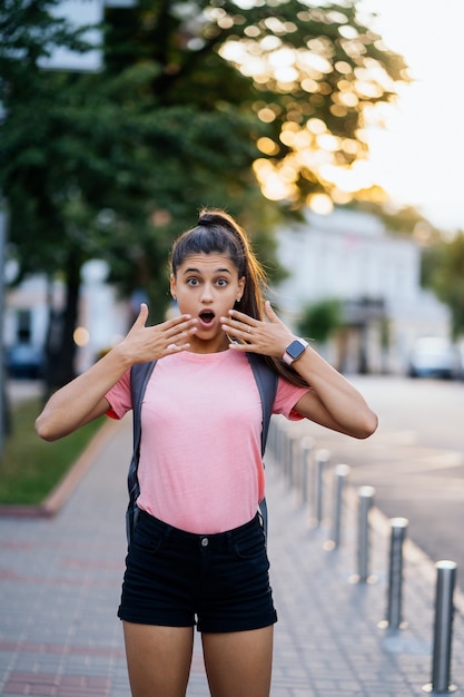 Zomer levensstijl mode portret van jonge verrast vrouw lopen op straat