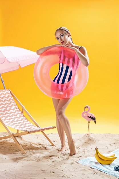 Zomerportret Het blonde vrouwelijke model stellen met zwemmende ring