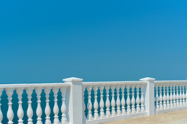 Zomeruitzicht met klassieke witte balustrade en leeg terras met uitzicht op het vakantie-idee van de Middellandse Zee Vrije ruimte voor tekst