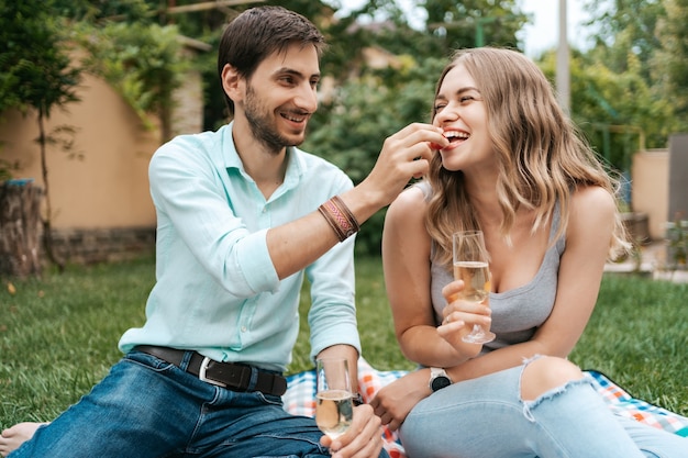 Zomervakantie, mensen, romantiek, dating concept, koppel mousserende wijn drinken terwijl u geniet van tijd samen thuis in de achtertuin
