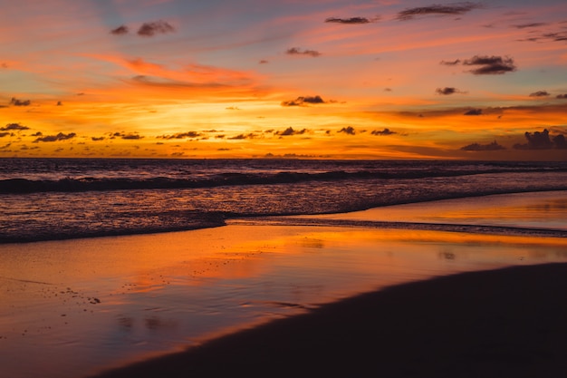 zonsondergang op de oceaan. mooie heldere hemel, weerspiegeling in water, golven.