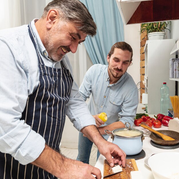 Zoon die zijn vader het koken bekijkt