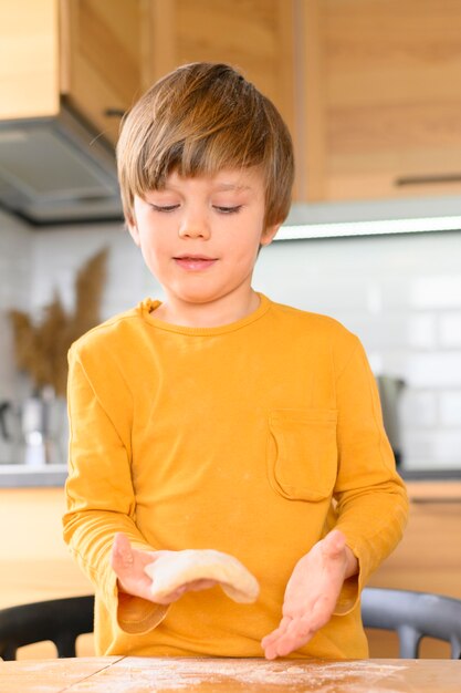 Zoon kneedt het deeg met zijn blote handen