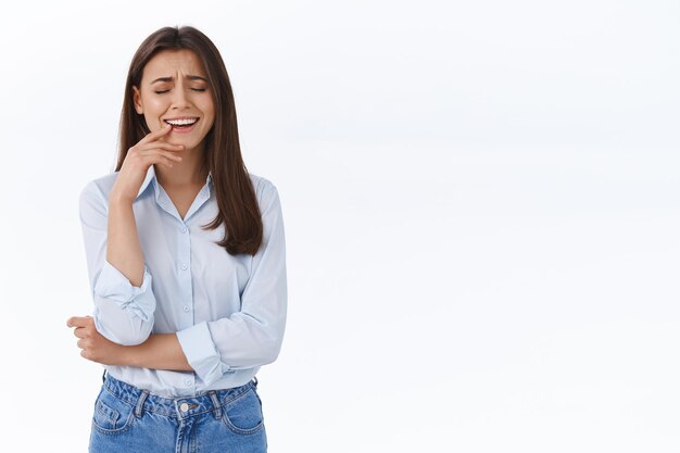 Zorgeloze volwassen vrouwelijke collega die met vrienden praat en lacht, bespreekt recent nieuws, roddelt tijdens de lunch, raakt de lip aan, sluit de ogen en giechelt vrolijk