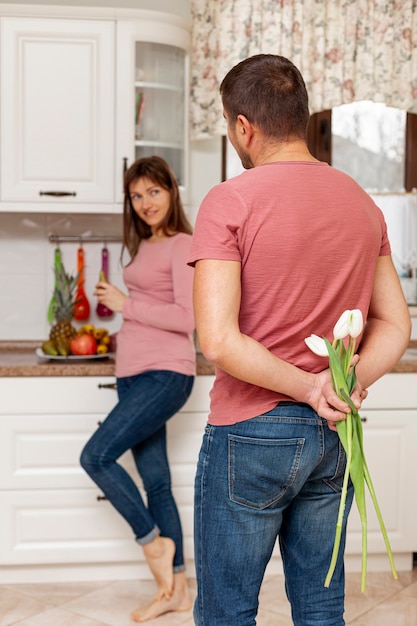 Zorgvuldige man die bloemen brengt naar zijn vrouw