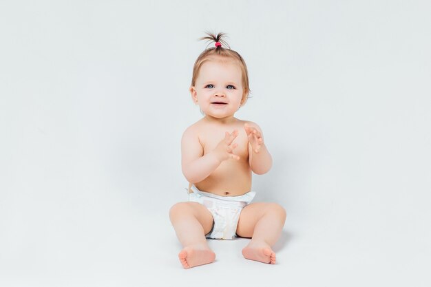 Zuigeling kind baby meisje peuter kruipen gelukkig kijken recht geïsoleerd op een witte muur