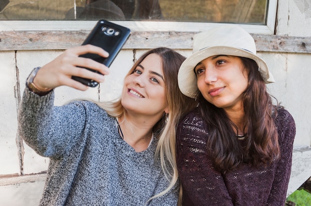 Zussen nemen selfie met hun mobiele telefoon