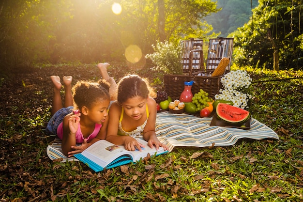 Zusters lezen op picknick doek