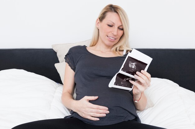 Zwangere vrouw die röntgenstraal bekijkt