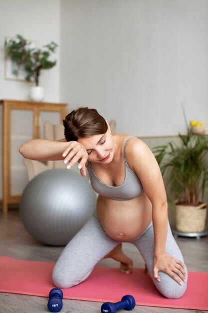 Zwangere vrouw die thuis traint