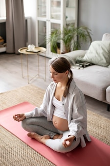 Zwangere vrouw die thuis yoga doet