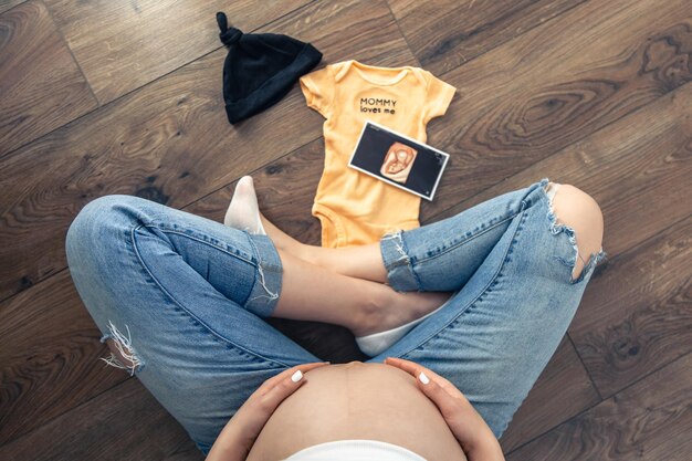 Zwangere vrouw echografie beeld en babyspullen een moeder verwacht een baby