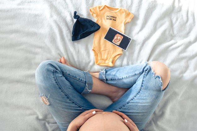 Gratis foto zwangere vrouw echografie beeld en babyspullen een moeder verwacht een baby