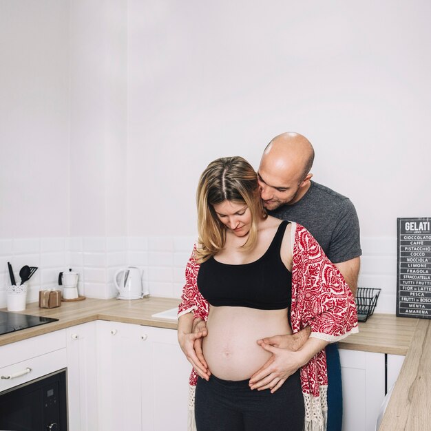 Zwangere vrouw en echtgenoot in keuken