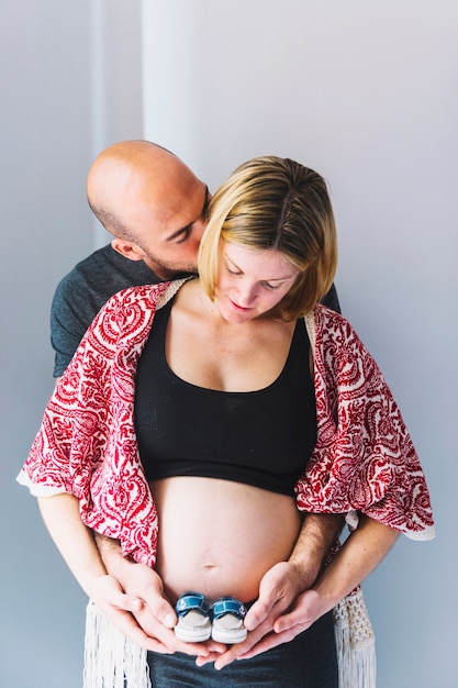 Zwangere vrouw en echtgenoot met babyschoenen