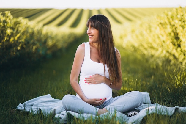 Zwangere vrouw het praktizeren yoga op gebied