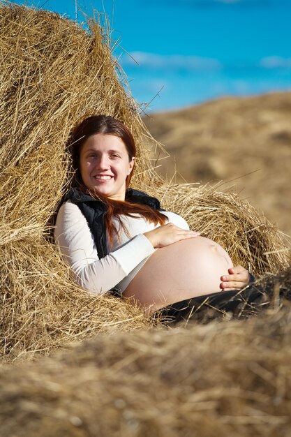 Zwangere vrouw op hooi