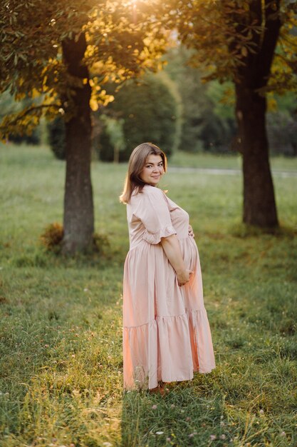 Zwangere vrouw poseren in het park