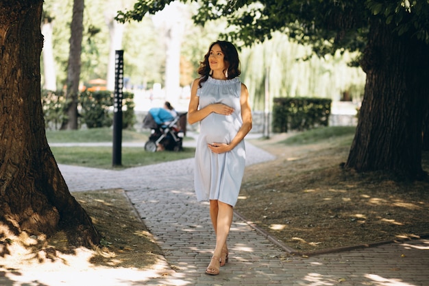Zwangere vrouw poseren in park
