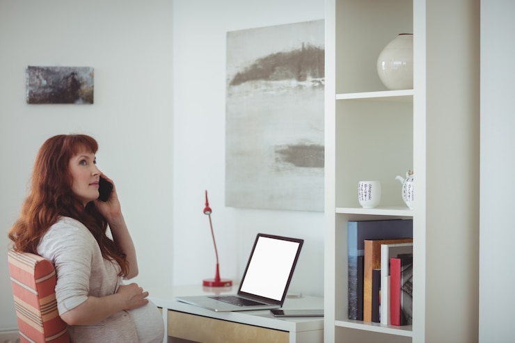 Gratis Foto zwangere vrouw praten op mobiele telefoon in de studeerkamer