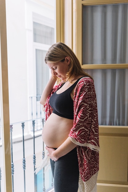 Zwangere vrouw voor balkon