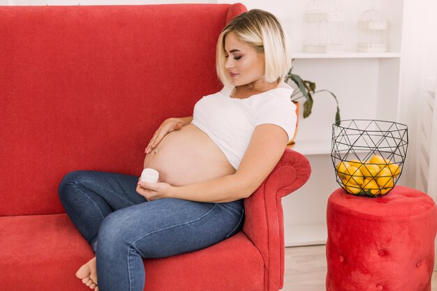 Gratis foto zwangere vrouw zittend op de bank