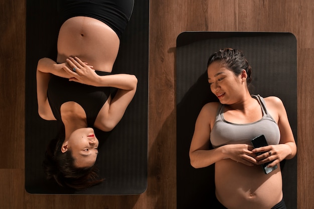 Gratis foto zwangere vrouwen die samen yoga beoefenen