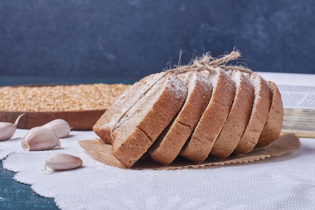 Zwart brood met knoflook op blauwe lijst.