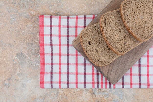 Zwart brood segmenten op een houten bord met tafellaken