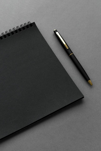 Gratis foto zwart notitieboekje met een pen