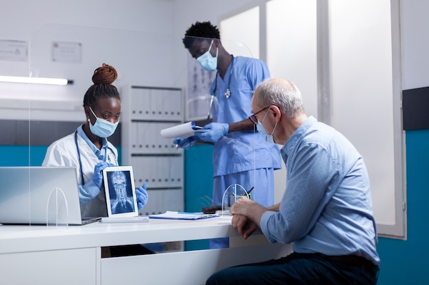 Zwart professioneel team van mensen die röntgenfoto's uitleggen