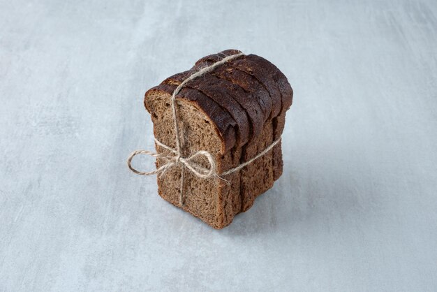 Zwart toastbrood vastgebonden met touw stenen oppervlak.