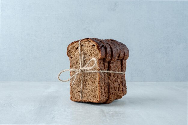 Zwart toastbrood vastgebonden met touw stenen oppervlak.