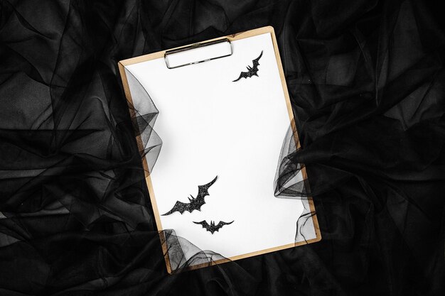Zwarte abstracte achtergrond met klembord en vleermuizen, concept voor halloween