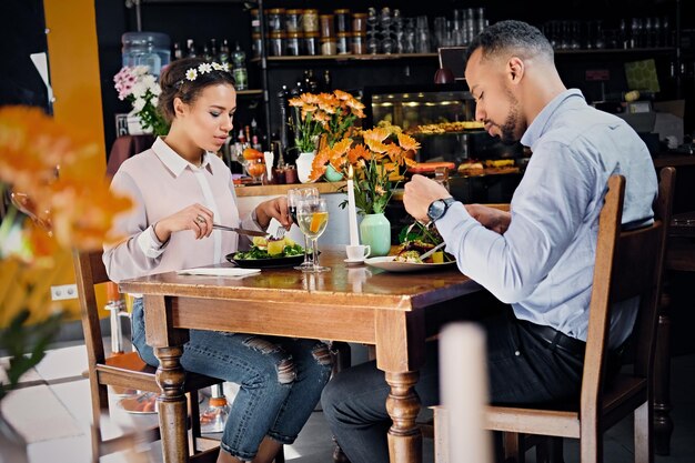 Zwarte Amerikaanse man en vrouw die veganistisch eten in een restaurant.