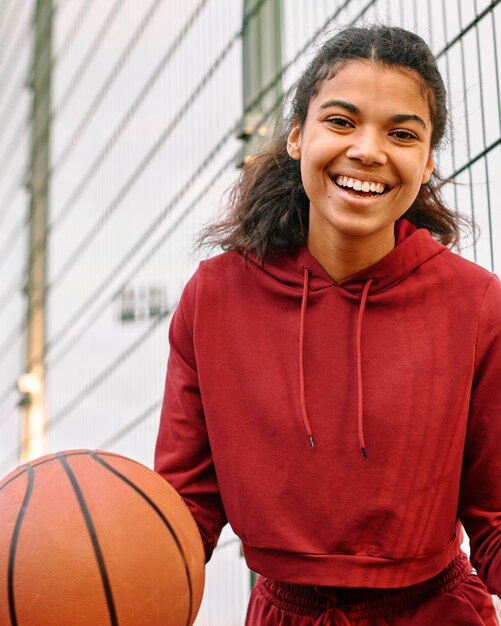 Zwarte Amerikaanse vrouw die een basketbal houdt