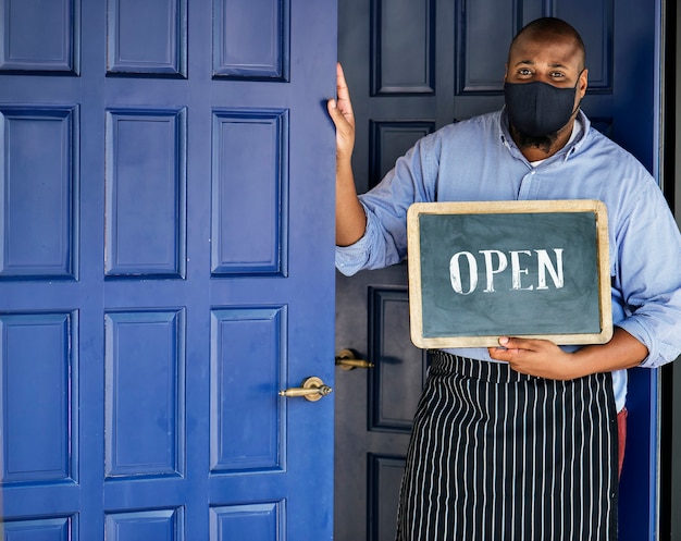 Zwarte bedrijfseigenaar in masker tijdens nieuwe normale postpandemie