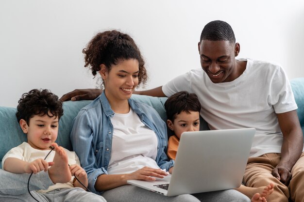Zwarte en gelukkige familie kijken met plezier tijdens het kijken naar iets op laptop