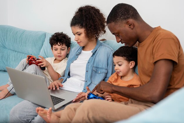 Zwarte en gelukkige familie kijken naar iets op laptop