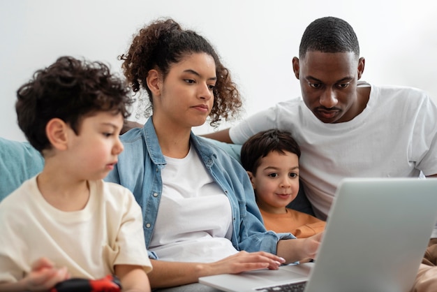 Zwarte en gelukkige familie samen kijken naar iets op laptop