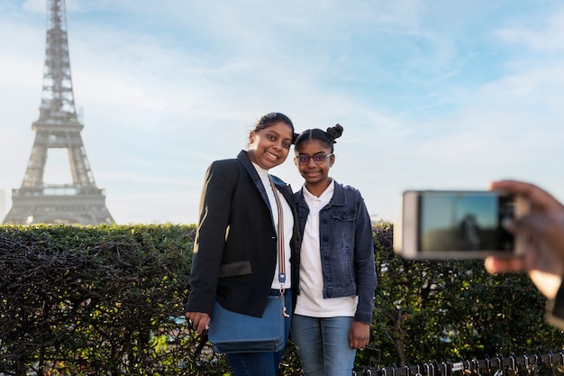 Gratis foto zwarte familie die een foto maakt tijdens hun reis naar parijs