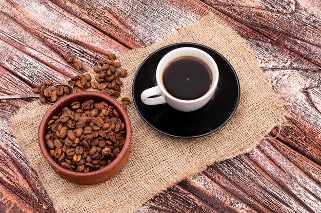 zwarte koffie en koffiebonen op houten oppervlak bovenaanzicht