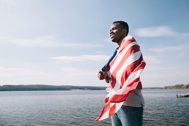 Zwarte patriottische man gewikkeld in Amerikaanse vlag