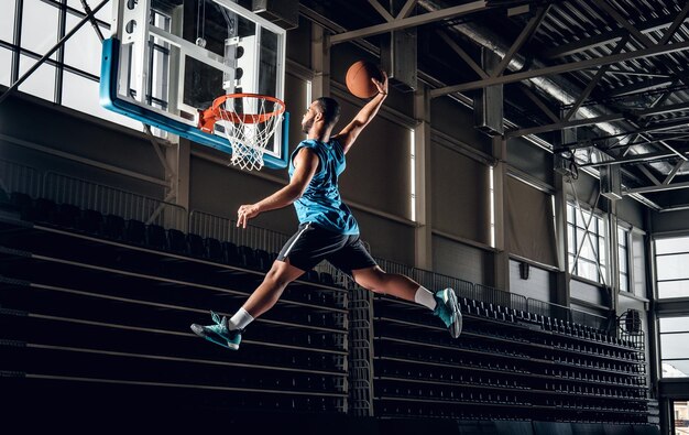 Zwarte professionele Zwarte basketbalspeler in actie in een basketbalveld.