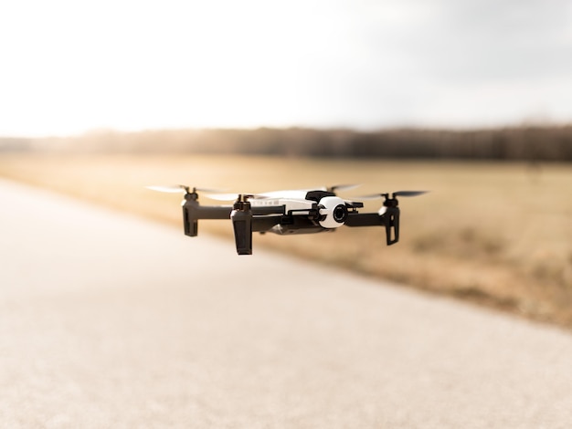 Zwarte quadcopter drone over een bewolkte hemel