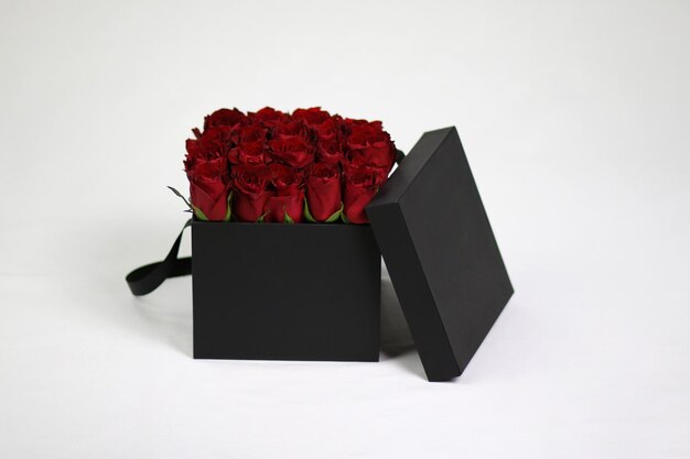 Zwarte vierkante geschenkbloembak met rode rozen erin