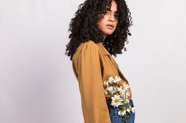 Gratis foto zwarte vrouw met bloemen in jeanszak