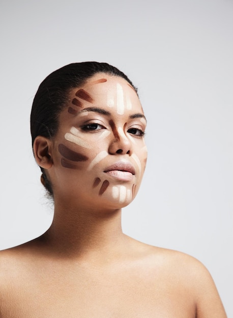 Zwarte vrouw met een markeerstift en tintencorrector op een gezicht