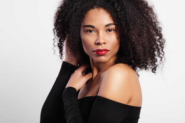 Zwarte vrouw met krullend haar en knalrode lippen