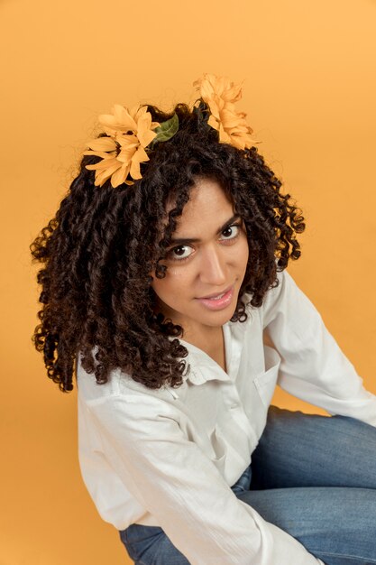 Zwarte vrouw zitten met bloemen in haar